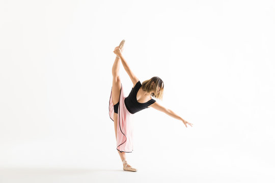 Young Ballet Dancer Doing Standing Split Over White Background