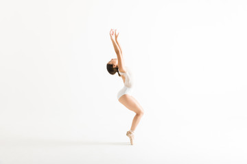 Young Ballerina With Arms Raised Balancing On Her Tiptoes