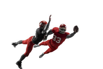 Active two american football player isolated on white background. Fit caucasian men in uniform with ball jumping over studio background in jump or motion. Human emotions and facial expressions concept