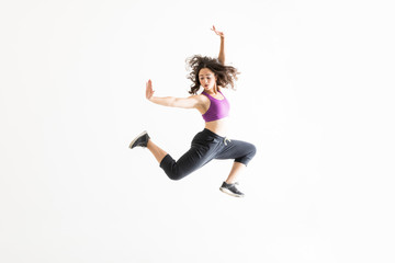 Woman In Midair Practicing Ballet Moves Against White Background
