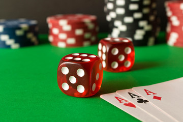Dice, poker chips and playing cards on the green table . Game concept. Games of chance