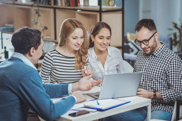 Obraz premium Total concentration. Pleasant four colleagues having meeting and calling online