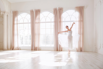 Ballerina dancing in a studio on white background window. - obrazy, fototapety, plakaty