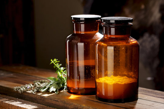 Vintage dusty medical or chemical bottles on a wooden table
