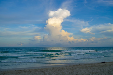 A colorful vertical cloud rising above the ocean. Tidal bore. Beach at sunset. Scenic Spots