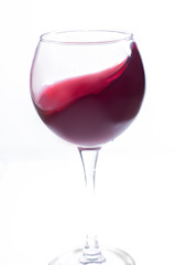 A glass with red wine on a white background. Isolate