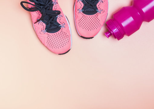 Fitness sneakers and bottle with water top view