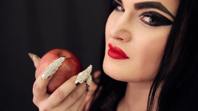 a young witch with an apple in her hands