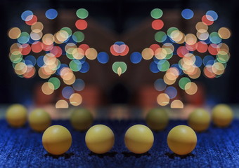 Yellow ping pong ball, with bokeh background, on black background
