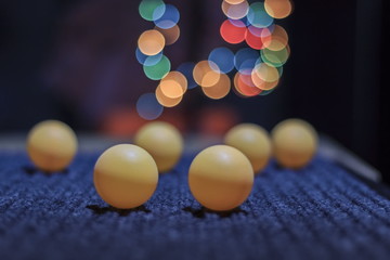 Yellow ping pong ball, with bokeh background, on black background