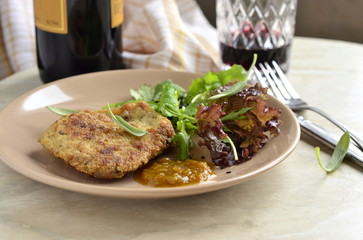 Fried pork chop with fresh herbs and fruit sauce