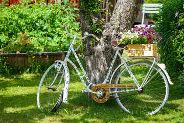 Fototapeta na wymiar Picture of old vintage bicycle with flowers on the green grass