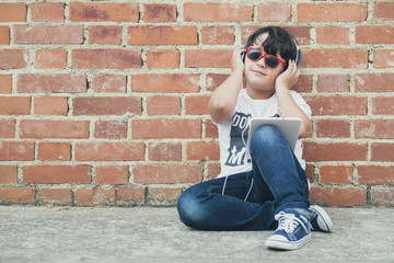 child with headphones connected with digital tablet