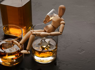 Wooden dummy drinking cold brandy or whiskey
