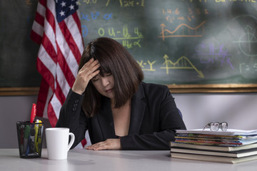 Portrait of a stressed teacher in her classroom