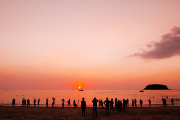 Silhouette image of tourists watching sunset at Patong beach, Phuket