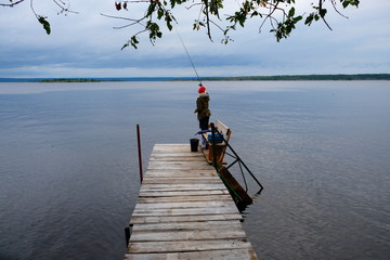 A woman is fishing from the dock