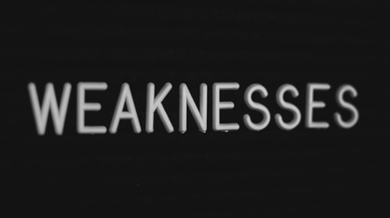 Word weaknesses written on the letter board. White letters on the black background