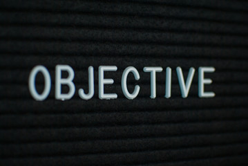 Word objective written on the letter board. White letters on the black background