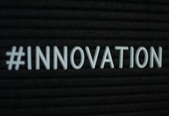 Word #innovation written on the letter board. White letters on the black background