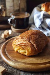 French breakfast: sweet puff pastry bun and cup of coffee