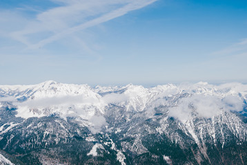Fototapeta na wymiar White snowy mountaon peaks. Sunny blue landscape in Austrian Alps. Clouds flying over the summits