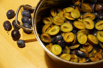 Autumn preserves. Plums in a pot, washed, halved, free of seeds.