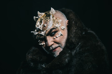 Alien, demon, sorcerer makeup. Horror and fantasy concept. Man with thorns or warts in fur coat....