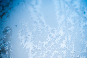 Frosty patterns on the frozen window are macro. Winter background