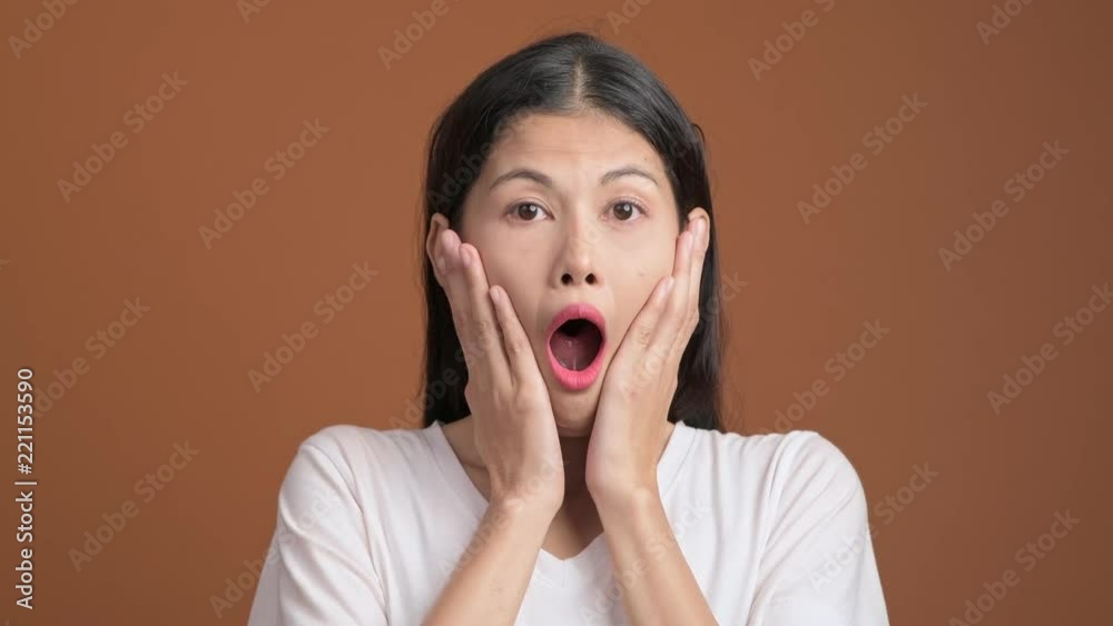 Sticker Surprise and shock woman isolated.  Portrait of asian woman in white t-shirt with shocking face expression looking at camera.