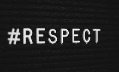 Hashtag word #respect written on the letter board. White letters on the black background