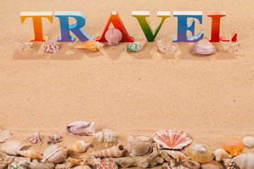 travel written in colorful letters with sea shell at the beach with copy space