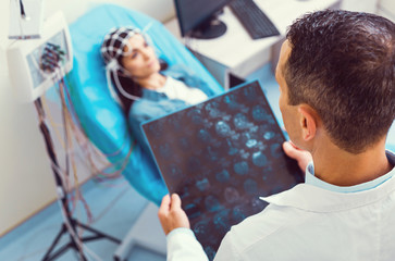 Total examination. Top view on a mature radiologist holding a computed tomography scan and...