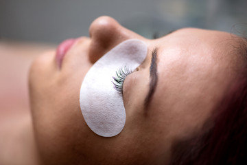 Fototapeta premium Beautiful Woman with long eyelashes in a beauty salon. Eyelash extension procedure