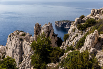 Fototapeta na wymiar aerial view of high cliffs, green vegetation and calm sea in Calanques de Marseille (Massif des Calanques), provence, france