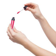 Female hands holding pink lipstick on white