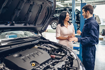 Car service center scene. The mechanic communicates with the client