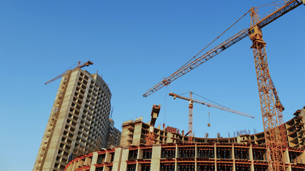 Construction site background. Four cranes near building.