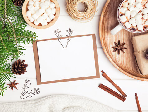 Christmas card mock-up on the white table with fir branches