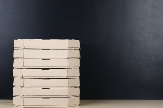 Stack Of Pizza Boxes On Blackboard Background