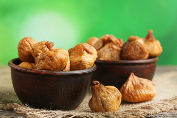 Dried figs in bowls on grey wooden table