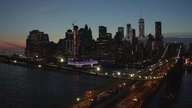 alt night view of downtown Manhattan flying backward along Brooklyn Bridge