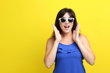 Fototapeta premium Young woman with sunglasses on yellow background