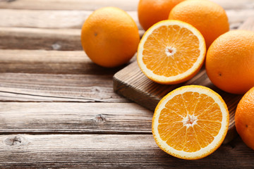 Orange fruit with cutting board on brown wooden table