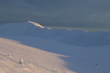 The observatory in the winter mountains is illuminated by the last rays of the sun. Observatory in the Carpathian Mountains on the mountain of Pip Ivan