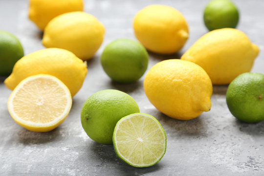 Ripe lemons and limes on grey wooden table