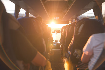 Background, bus interior. The salon of the bus with people fill the sun with light in the sunset....