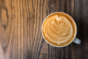 Latte art coffee cup on wooden table, Flat lay