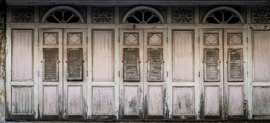 Closed old shuttered weathered wooden window in the Songkhla province, Thailand