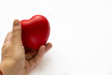 Fototapeta premium Close up red heart symbol of love isolated on white backgroound. Hand holds red heart. St. Valentines day. Objecr photography. Health and cardiovascular risk of diseases. Cardiology news. 